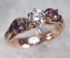 Item# CD37: Custom 14kt rose gold engagement ring set with a center .50ct diamond and two 3mm amethysts. Caution, amethyst is a soft stone.