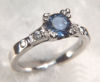 Item# CD27: Hand made antique style engagement ring set with a 1.53ct blue sapphire and four .03ct round brilliant diamonds.