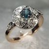 Item# CD35: Custom antique style 18KY gold/platinum engagement ring set with a center blue sapphire and diamond melee. The Marda.