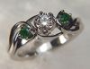 Item# CD5: Platinum engagement ring set with a .40ct round brilliant cut diamond and two .10ct round emeralds.