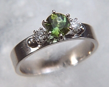 14kt white gold 'Laura' set with a .89ct round green tourmaline and two .10ct side diamonds.