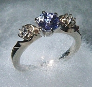 Two tone 'Siri' Engagement Ring with a 1.03ct tanzanite and two .10ct round diamonds. Shank is of 14kt white gold with 14kt yellow accents around the diamonds. Note: tanzanite is a soft stone.