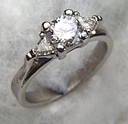 14Kt white gold 'Susan' set with a .50ct round brilliant cut diamond and two 3mm triangle cut diamonds on either side.